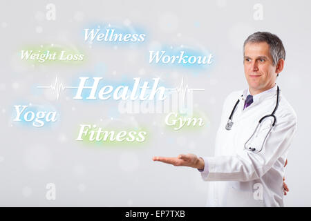 Clinical doctor pointing to health and fitness collection of words Stock Photo