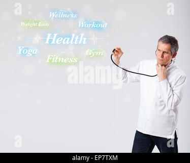 Clinical doctor pointing to health and fitness collection of words Stock Photo