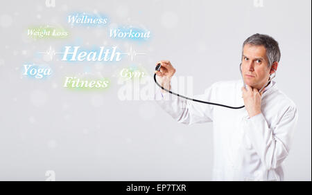 Clinical doctor pointing to health and fitness collection of words Stock Photo