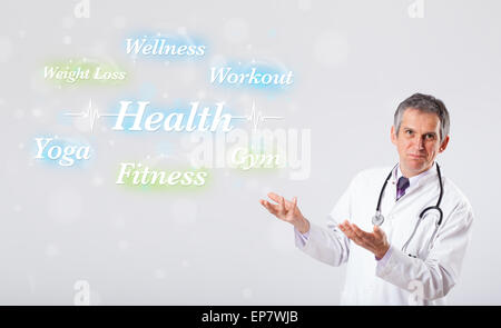 Clinical doctor pointing to health and fitness collection of words Stock Photo