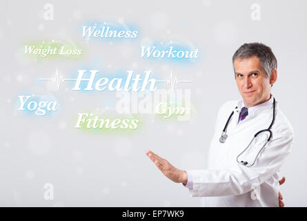 Clinical doctor pointing to health and fitness collection of words Stock Photo