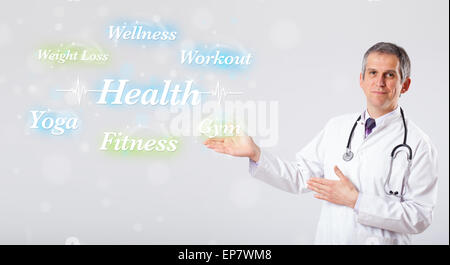 Clinical doctor pointing to health and fitness collection of words Stock Photo