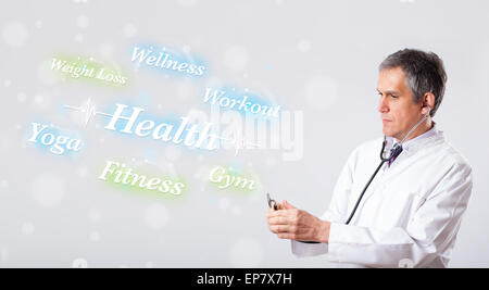 Clinical doctor pointing to health and fitness collection of words Stock Photo