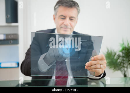 Businessman using futuristic touchscreen to view data Stock Photo