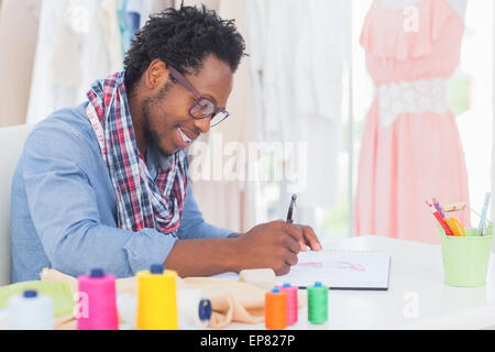 Attractive fashion designer sitting at his desk drawing Stock Photo