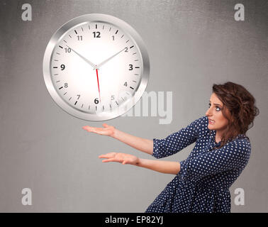 Attractive lady holding a huge clock Stock Photo