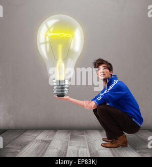 Attractive man holding realistic 3d light bulb Stock Photo