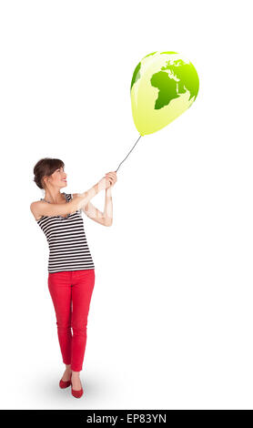 Happy lady holding a green globe balloon Stock Photo