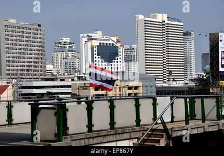 Bangkok, Thailand:  A Thai flag flies on the Ploenchit BTS Skytrain platform with modern hotels in distance Stock Photo