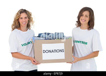 Two cheerful volunteers carrying clothes donation box Stock Photo