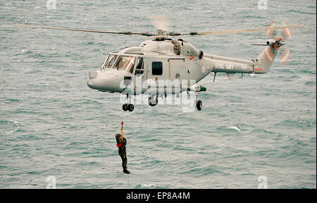 AJAXNETPHOTO - 20th August, 2009. BOURNEMOUTH, ENGLAND - ROYAL FLEET AUXILLIARY VISITOR - CPL ALAN HOCKING OF THE ROYAL MARINES COMMANDO DISPLAY TEAM BEARING A LETTER FROM THE FIRST SEA LORD, IS LOWERED BY WINCH FROM A LYNX ONTO THE FLIGHT DECK OF RFA LSDA MOUNTS BAY OFF BOURNEMOUTH DURING THE SUMMER AIR SHOW. PHOTO:JONATHAN EASTLAND/AJAX REF:920081 09 7 Stock Photo