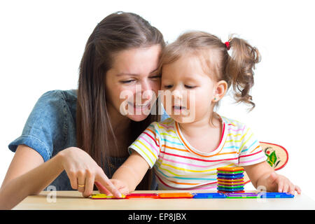 child and mom playing together with toys Stock Photo