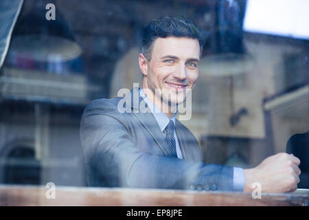 Portrait of a cheerful businessman sitting at the table in cafe Stock Photo