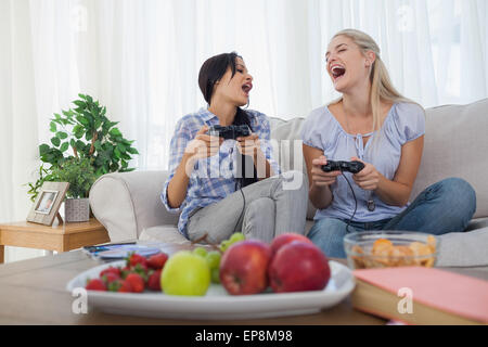 Laughing friends playing video games and having fun Stock Photo