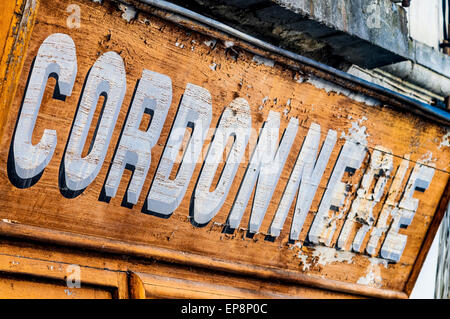 Faded peeling paint Cordonnerie shop sign - France. Stock Photo
