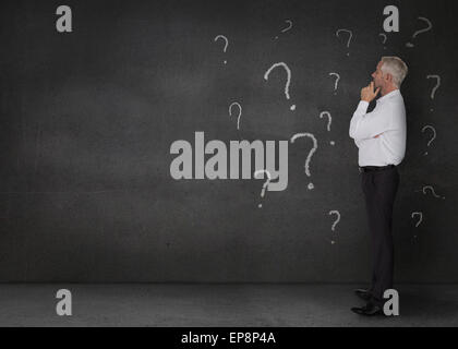 Thoughtful businessman standing in a dark room Stock Photo