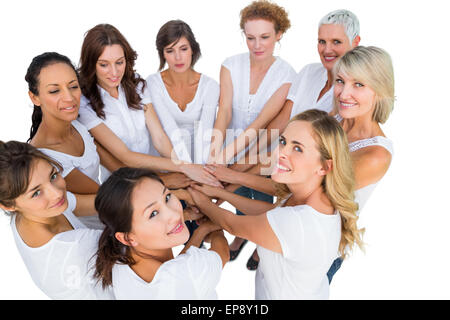Female models joining hands in a circle and looking at camera Stock Photo