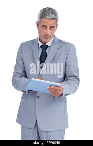 Serious businessman using tablet pc looking at camera Stock Photo