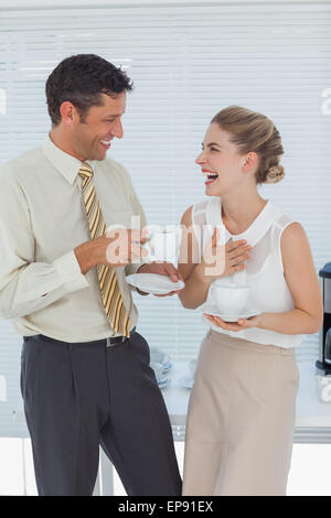 Stylish workmates laughing while having coffee together Stock Photo