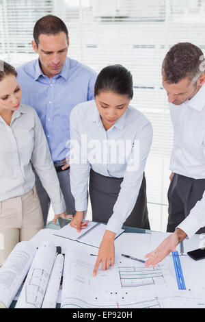 Focused architects interacting and analyzing plans together Stock Photo