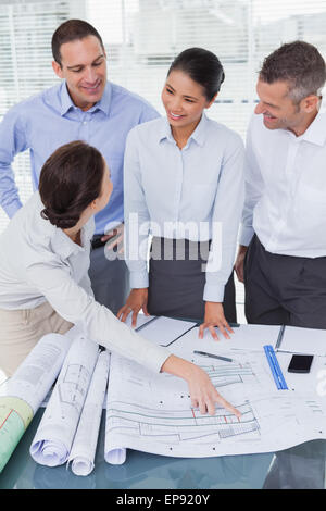 Happy architects interacting and analyzing plans together Stock Photo