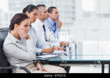 Businesswoman getting bored while attending presentation Stock Photo
