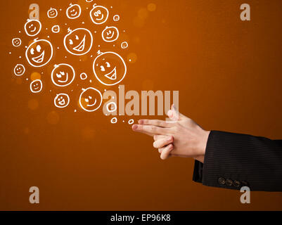 Group of happy smiley faces coming out of gun shaped hands Stock Photo