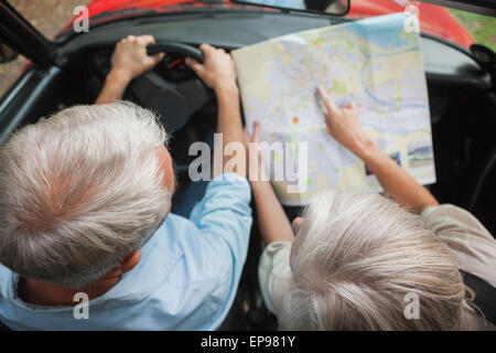 Overhead view of mature couple on holidays reading map Stock Photo
