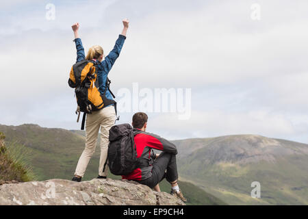 Excited couple reaching the top of their hike Stock Photo
