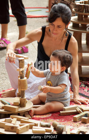 Mother helping her son to build a tower with wooden blocks Stock Photo