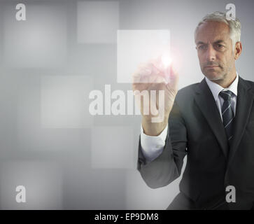 Serious businessman touching empty pane on digital screen Stock Photo