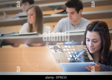 Focused pretty student working on her futuristic tablet Stock Photo