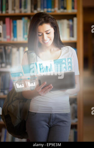 Smiling pretty student working on her futuristic tablet Stock Photo