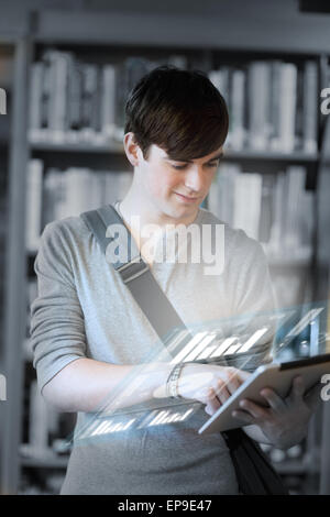 Focused student analysing graphs on his digital tablet Stock Photo