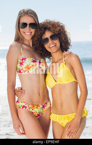 Two pretty friends in bikinis wearing sunglasses posing Stock Photo