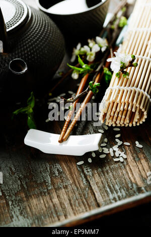 Chinese Tea Set,chopsticks and sakura branch on rustic wooden table Stock Photo