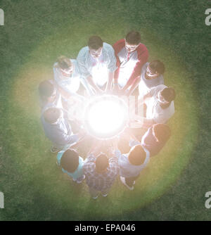 team circle surrounding glowing orb Stock Photo