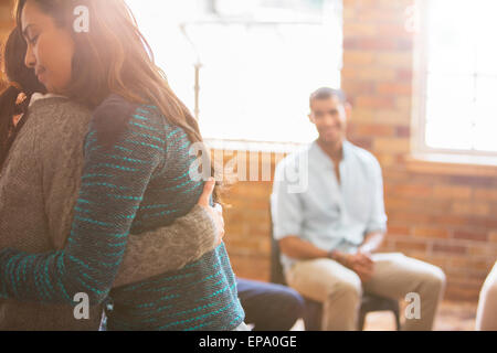 woman hugging group therapy session Stock Photo