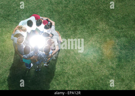 team huddling circle glowing orb field Stock Photo