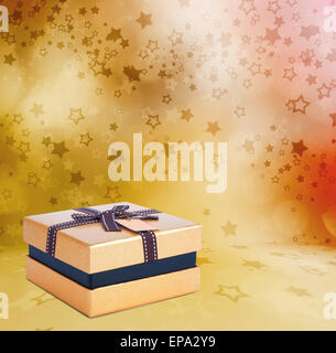 Beautiful Gift gold box with bow on the abstract star background with bokeh effect Stock Photo