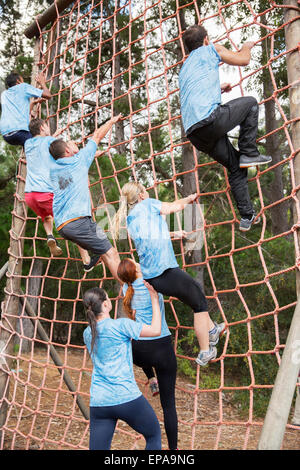 people climbing net boot camp obstacle course Stock Photo