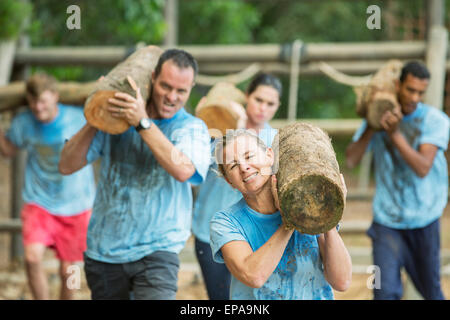 people running log boot camp obstacle course Stock Photo