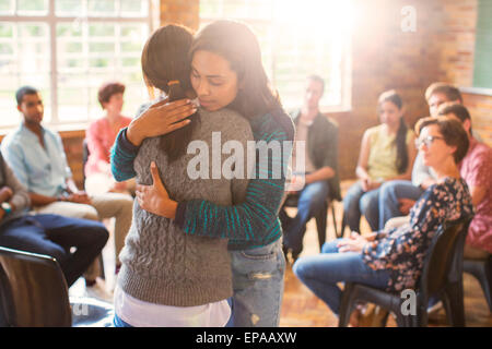 woman hugging group therapy session Stock Photo