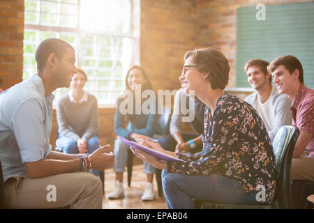group watching man woman talking group therapy Stock Photo