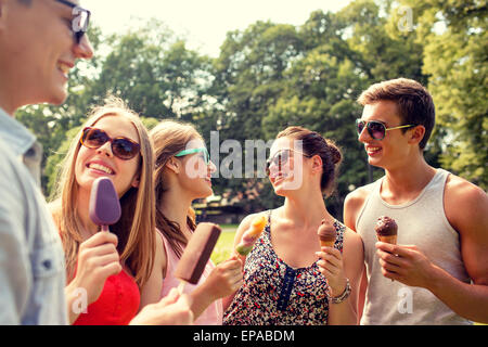 group of smiling friends with ice cream outdoors Stock Photo