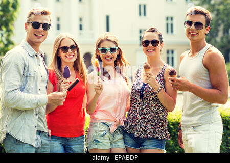 group of smiling friends with ice cream outdoors Stock Photo