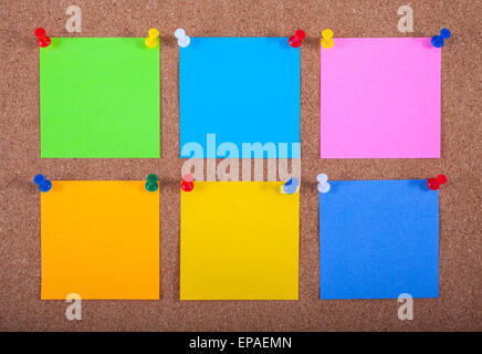 Six blank sticky notes pinned onto a noticeboard. Stock Photo