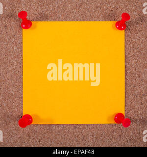 Blank orange note paper pinned to a Noticeboard. Stock Photo
