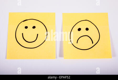 Happy and Sad Faces on Two Pieces of Memo Paper. Stock Photo