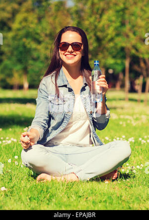smiling young girl with bottle of water in park Stock Photo